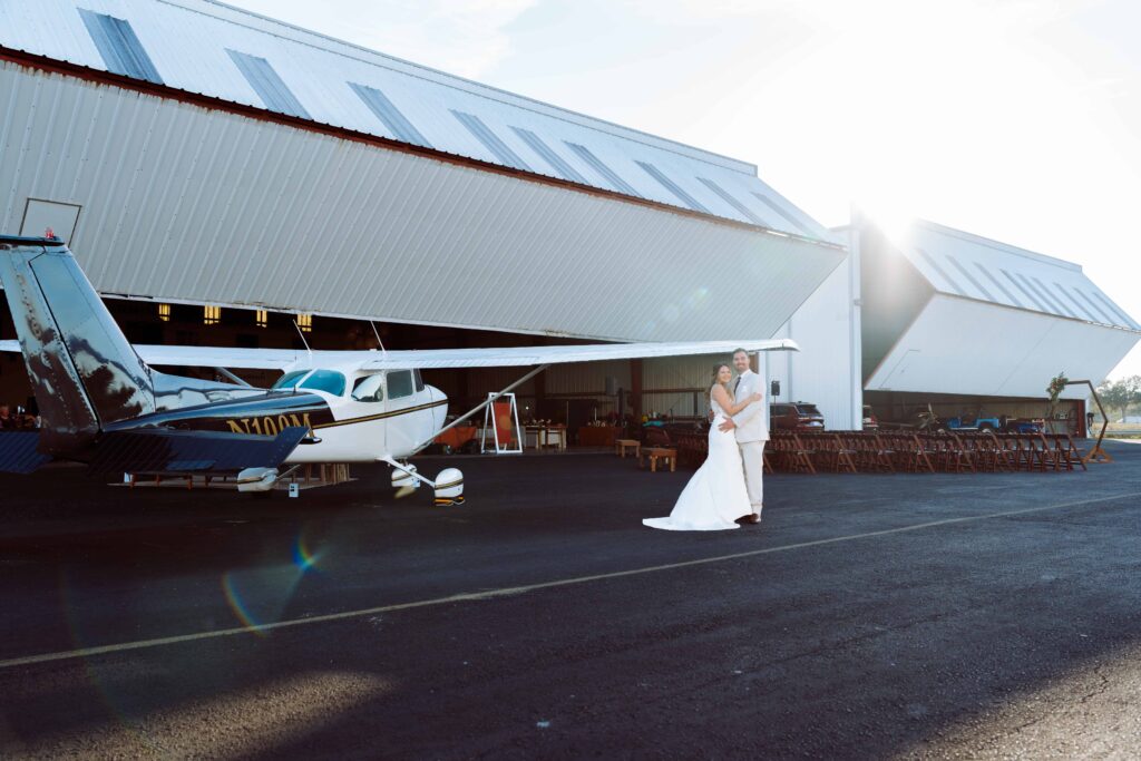 Couple portrait at airport hangar wedding in Sarasota with Cesna airplane